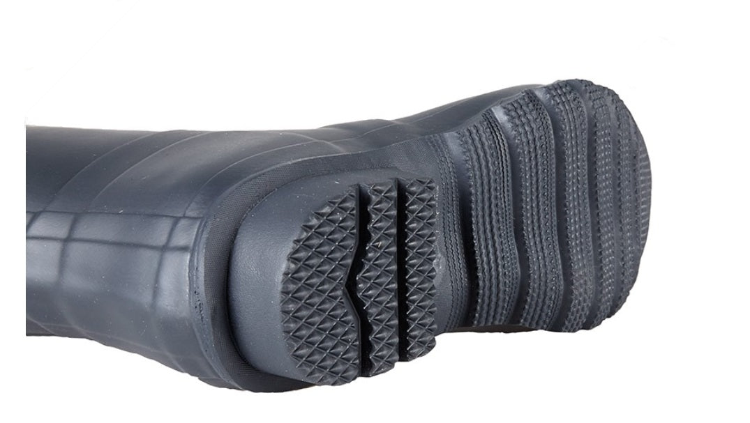 Close-up of a black rubber boot sole with tread pattern on a white background UK Size 15